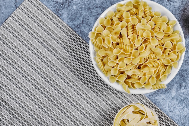 A bunch of uncooked pasta on marble.