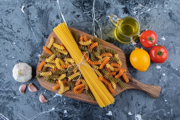 Букет из сырых спагетти в веревке с разноцветными макаронами и овощами.