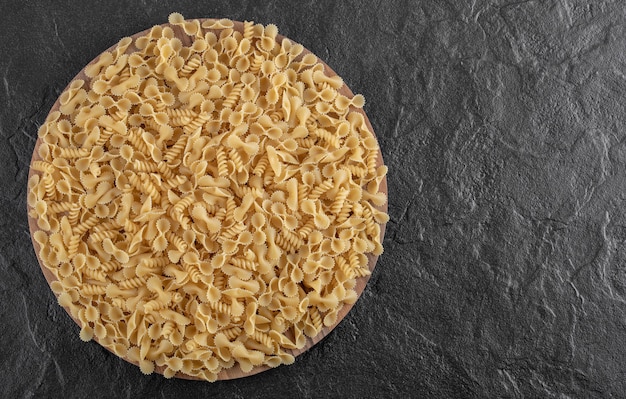 Foto gratuita mazzo di pasta varia sul piatto di legno. foto di alta qualità