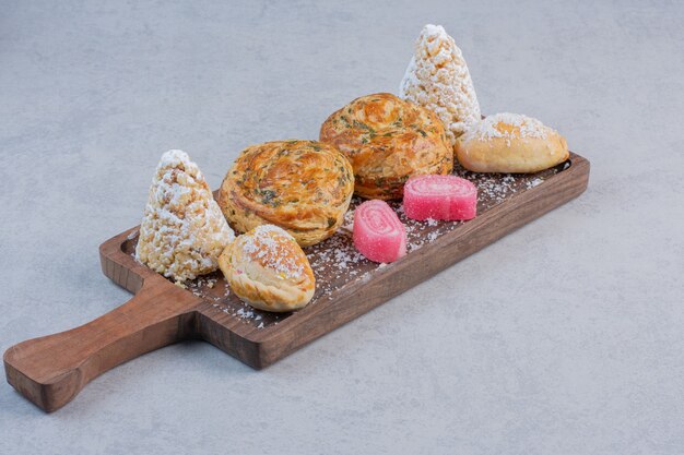 Bunch of various sweets on wooden board. 