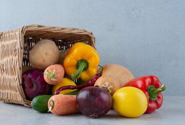 Bunch of various vegetables out of wooden basket.