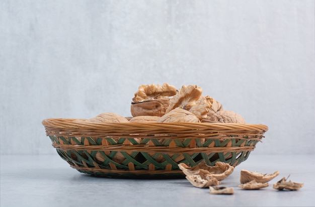Bunch of walnuts and kernels in ceramic bowl