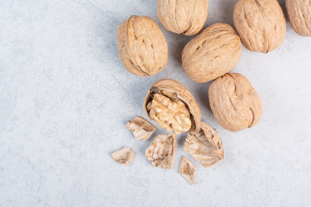 Bunch of walnuts and kernels on stone surface