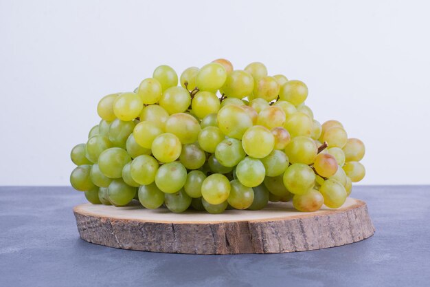 A bunch of wine grapes on a wooden board.