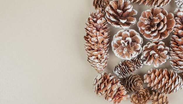 Bunch of wooden pine cones placed on beige.