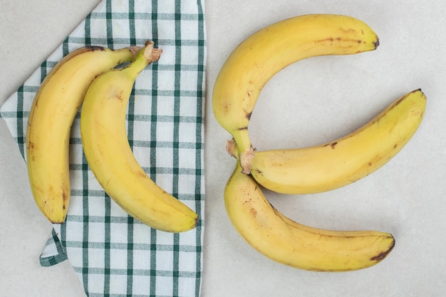 Mazzo di banane gialle sulla tovaglia a righe