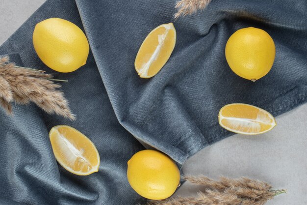 Bunch of yellow lemons on blue cloth.