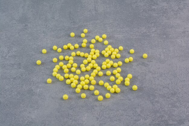 Bunch of yellow pills on marble table.