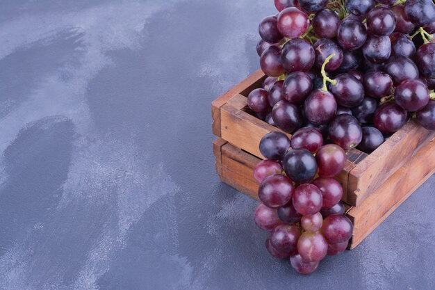 Bunches of grape in a wooden tray.