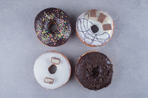 Bundle donuts with various toppings on marble surface