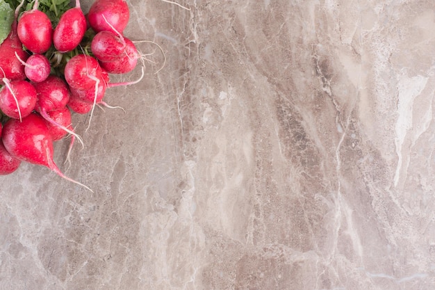 Free photo bundle of red turnips on marble surface