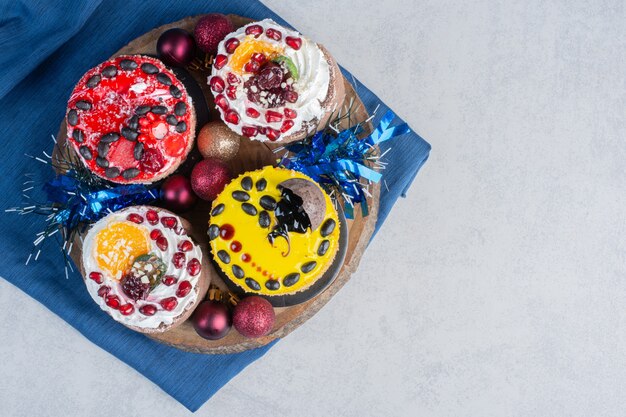 A bundle of small cakes on a wooden board on marble surface