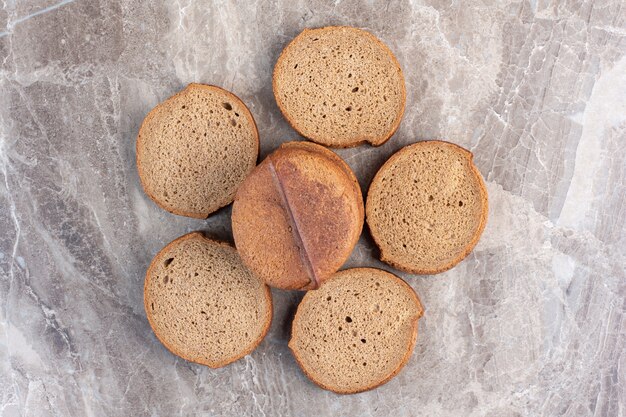 Bundled slices of black bread on marble.