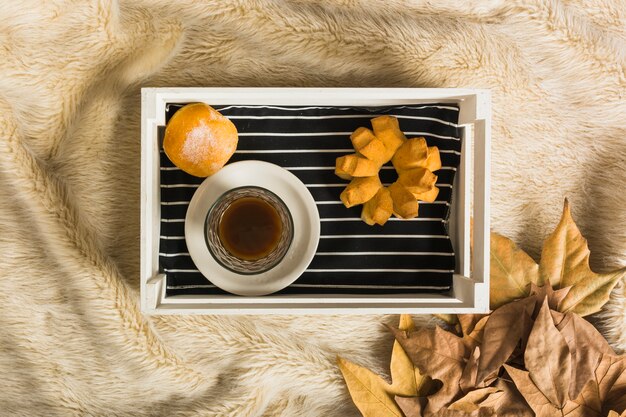 Buns and coffee near dried leaves