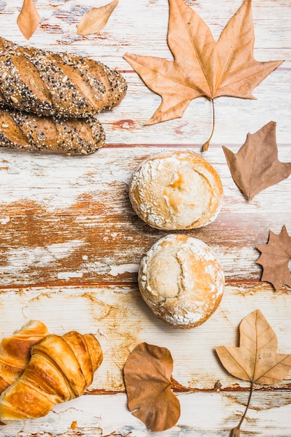 Foto gratuita panini e foglie vicino al pane fresco