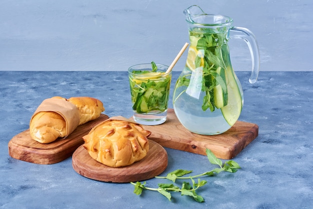 Buns with mojito on a wooden board on blue