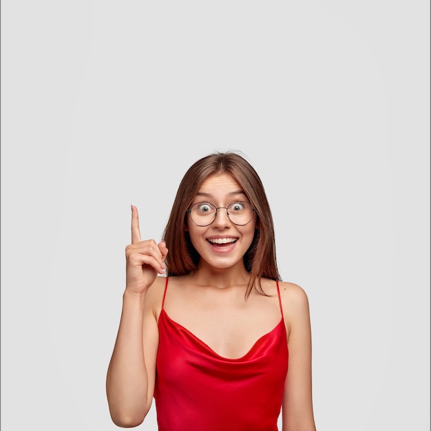 buoyant brunette young woman posing against the white wall