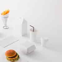Free photo burger; disposal cup; french fries and food parcel on white background