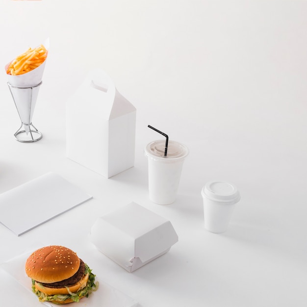 Burger; disposal cup; french fries and food parcel on white background