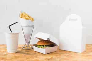 Free photo burger; french fries and disposal cup on wooden table