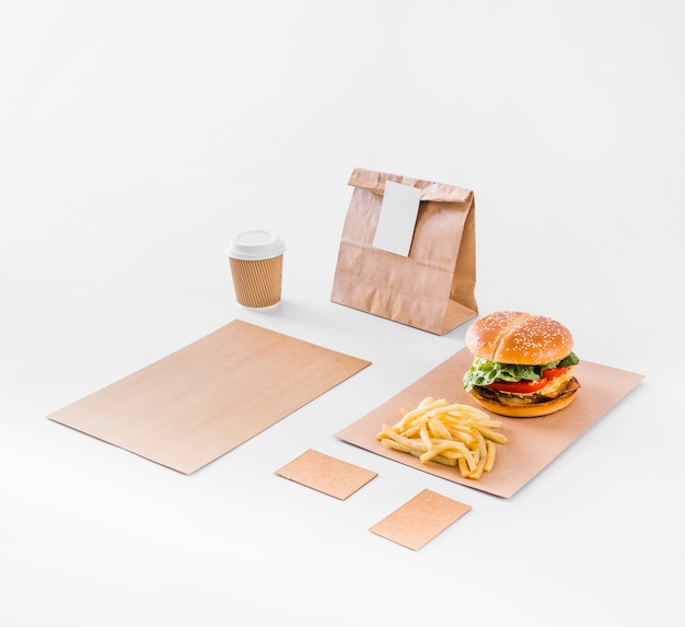 Burger; french fries; parcel and disposal cup on white backdrop