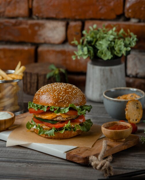 A burger served with melted cheddar cheese and sumakh on a rustic table