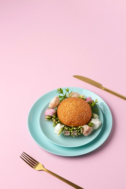 Burger with flowers on plate high angle