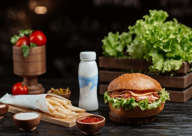 Foto gratuita hamburger con patatine fritte su un tavolo da cucina in legno