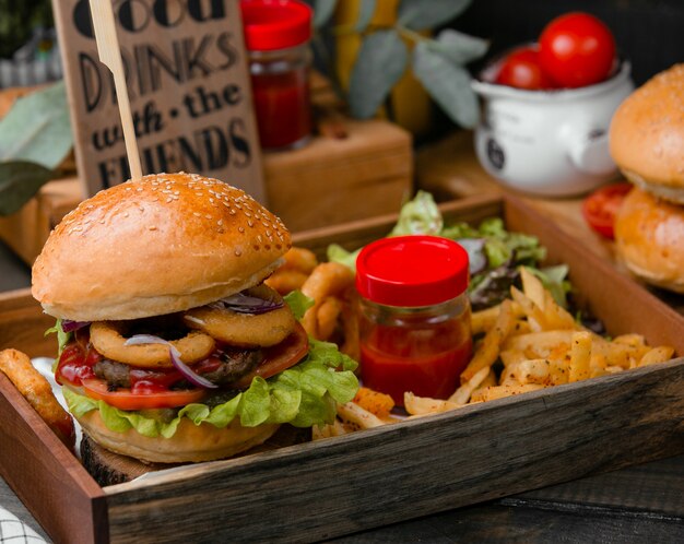 Burger with fries and tomato sauce.