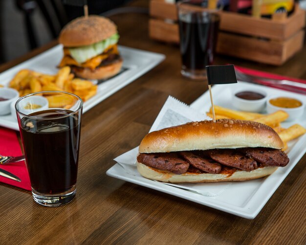 Burgers with steaks and glass of coca cola.