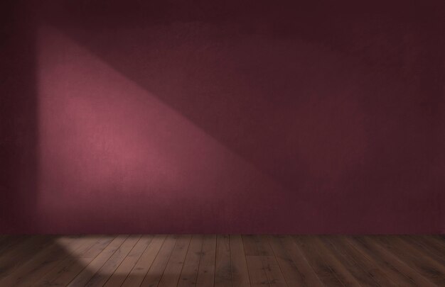 Бордово-красная стена в пустой комнате с деревянным полом