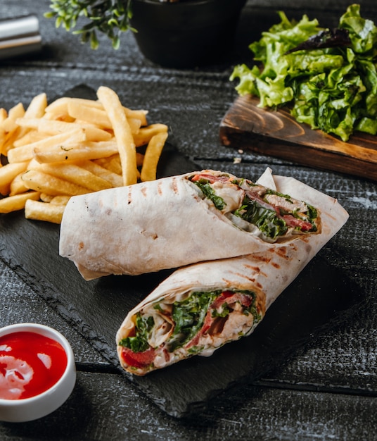Buritto with chicken and french fries on the table