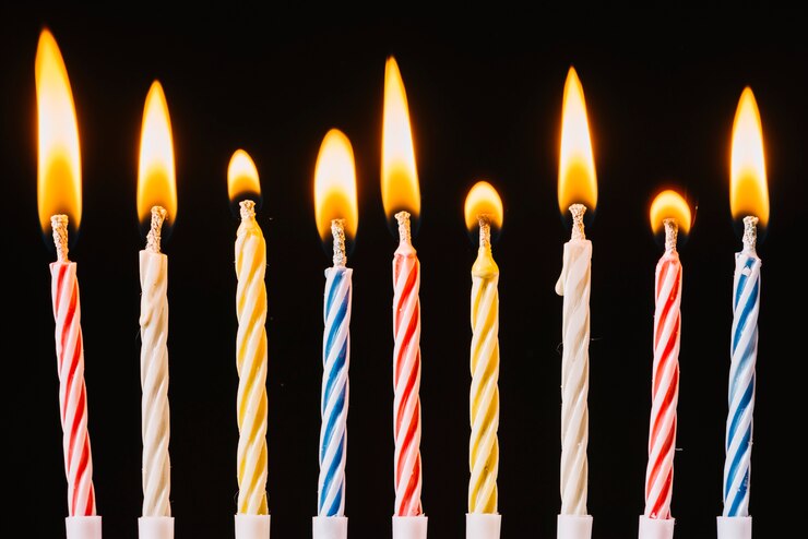 Free Photo burning birthday candles on black background