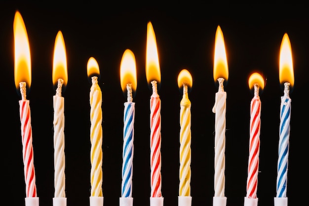 Burning birthday candles on black background