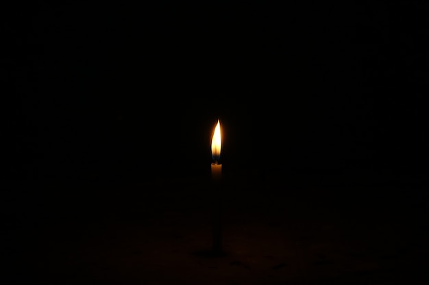 Бесплатное фото Горящая свеча на темном фоне