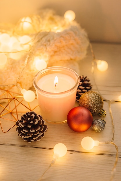 Free photo burning candle with scarf on wooden table