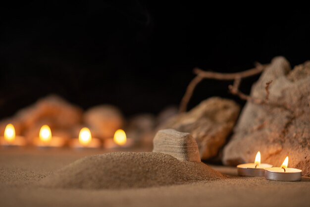 Burning candles with stones around little grave as memory funeral death