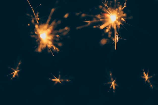 Burning christmas sparklers isolated on dark backdrop