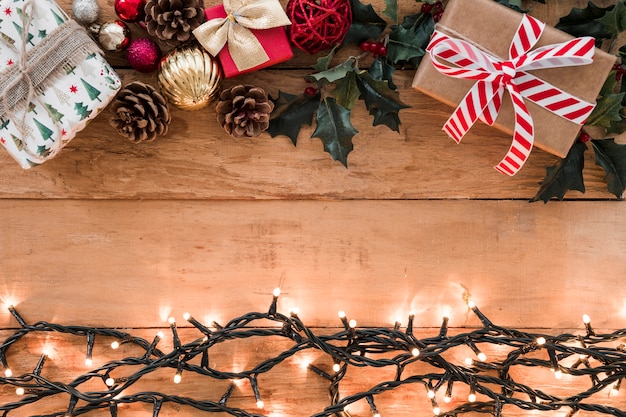 Burning garland with gift boxes on table 