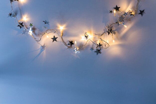 Burning garland with spangles on blue table