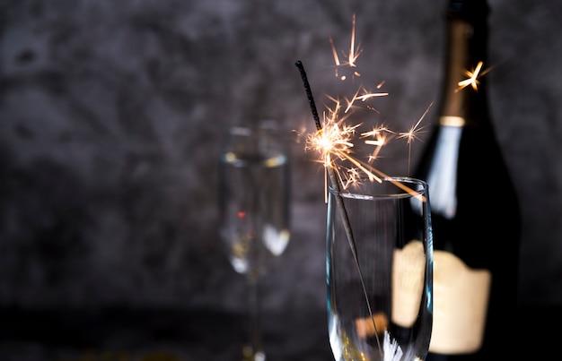 Burning sparkler in transparent wine glass