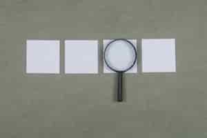 Free photo business analysis concept with sticky notes, magnifying glass on grey surface flat lay.