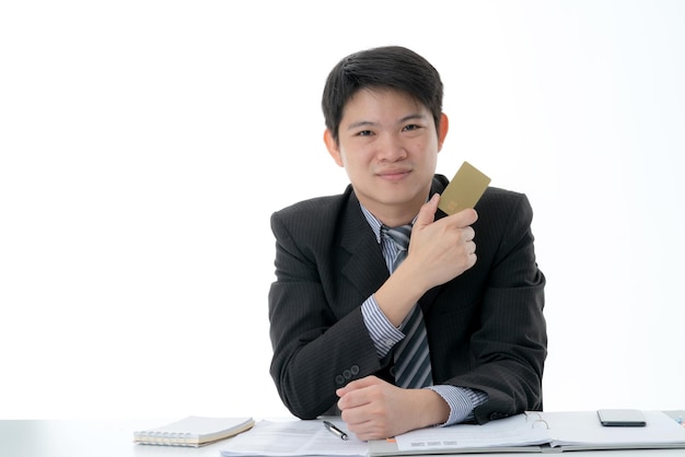 Деловой азиатский мужчина держит кредитную карту в руках, готовую к покупкам концепции бизнес-идей