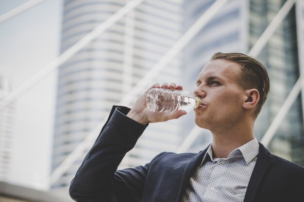 ビジネスマンビジネスセンターの前に残りの飲み水を取る。