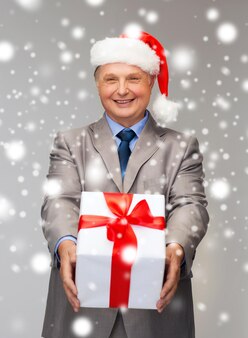 비즈니스, 크리스마스, 크리스마스, 행복 개념 - 양복을 입은 웃는 노인과 선물이 있는 산타 도우미 모자