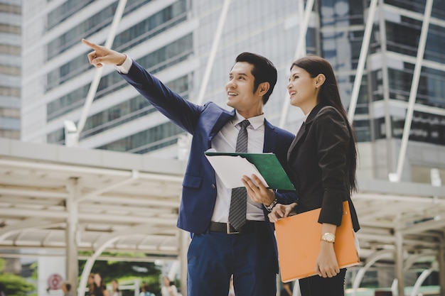 Business colleague talking and viewing documents outdoor