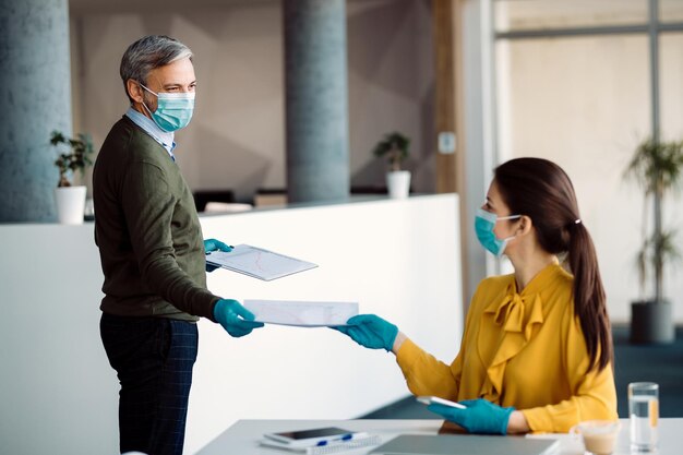 Business colleagues cooperating while working in the office during coronavirus pandemic