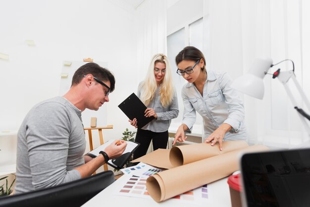 Business colleagues looking on cardboard sheet