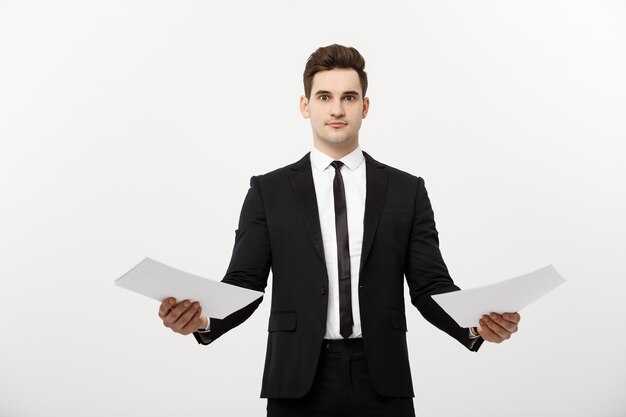 Бизнес-концепция: внимательный красивый бизнесмен, сравнивая бумажный отчет. Изолированные на белом сером фоне.