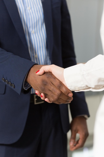 ビジネスコンセプト。握手するビジネスマンは、会社の会社間で相互合意を示しています。
